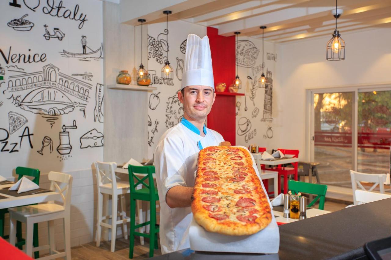 Sealine Beach, A Murwab Resort Mesaieed Buitenkant foto A pizzaiolo with a metre-long pizza